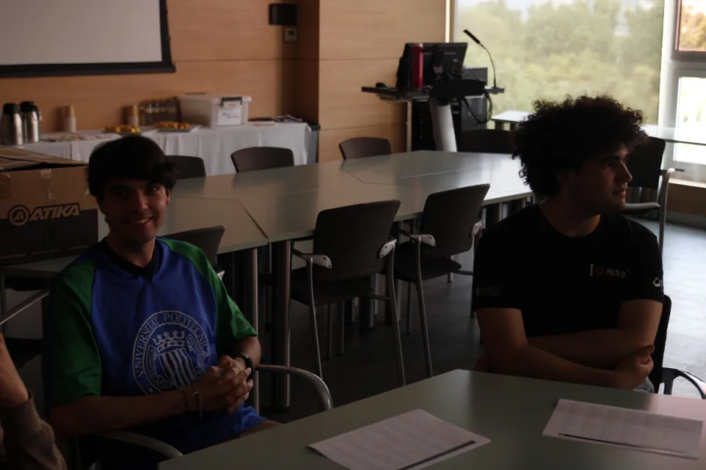 Dos estudiantes sentados a las mesas del aula durante el taller