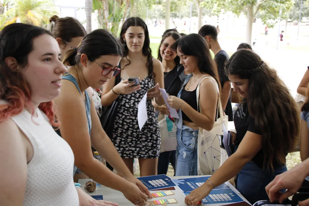 Estudiantes recogen folletos y material en la mesa informativa del CEUPV