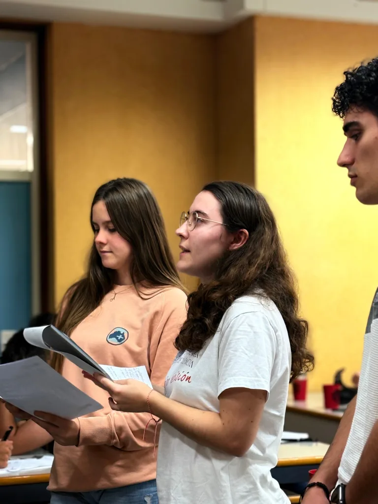 Participantes de pie durante una simulación: una de ellas lee en voz alta unos documentos