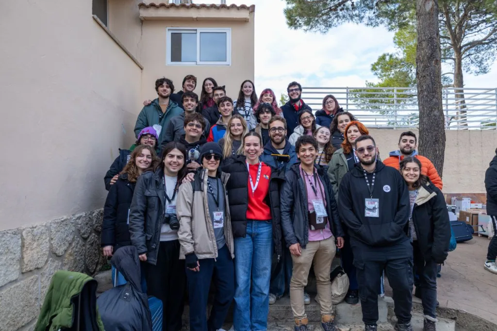 Foto de grupo del equipo de organización, con sus acreditaciones, en unas escaleras al aire libre