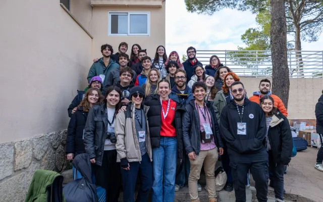 Foto de grupo del equipo de organización, con sus acreditaciones, en unas escaleras al aire libre