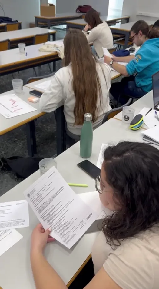 Participantes sentados en un aula leyendo los documentos impresos de un caso práctico