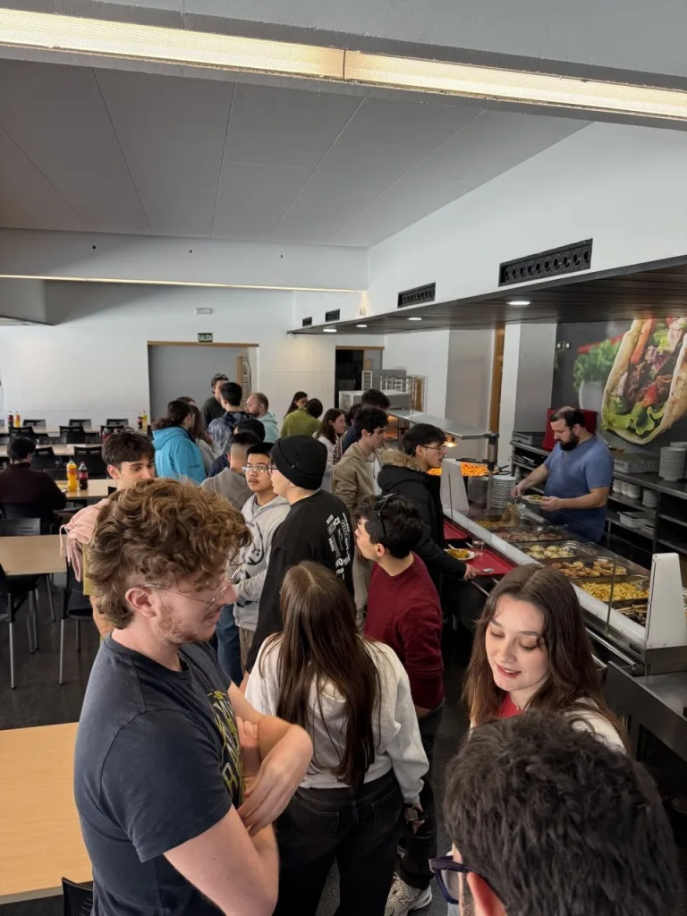 Participantes haciendo cola en el comedor para recoger la comida